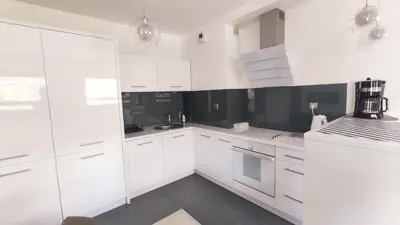 a white kitchen with white cabinets and appliances at Łokietka 8B by Homeprime in Kraków