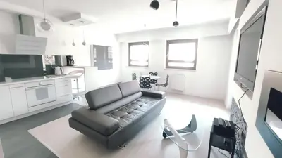 a living room with a couch and a kitchen at Łokietka 8B by Homeprime in Kraków