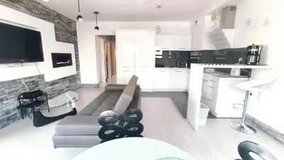 a living room with a couch and a kitchen at Łokietka 8B by Homeprime in Kraków