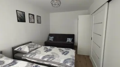 a bedroom with a bed and a chair at Apartamenty AgPa7 in Zator