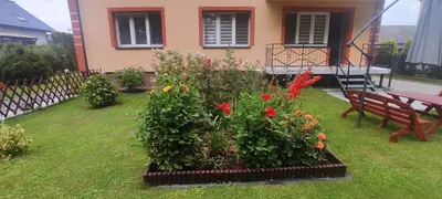 a garden with flowers in front of a house at Apartamenty AgPa7 in Zator