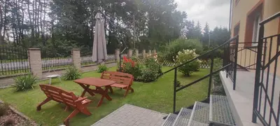 a patio with two benches and a table and an umbrella at Apartamenty AgPa7 in Zator