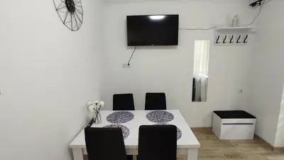 a dining room table with chairs and a tv on the wall at Apartamenty AgPa7 in Zator