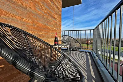 a metal bench on a balcony with a bottle of wine at HARMONY Apartment - Zator Energylandia in Zator