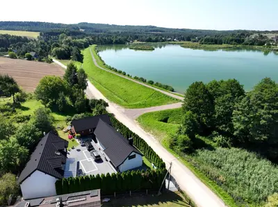 an aerial view of a house next to a lake at Apartamenty na Jurze in Siamoszyce