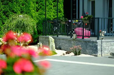 a garden with pink flowers in front of a house at Apartamenty na Jurze in Siamoszyce