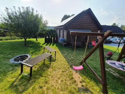 a park with a bench and a swing and a house at Apartamenty na Jurze in Siamoszyce