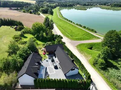 an aerial view of a house next to a lake at Apartamenty na Jurze in Siamoszyce