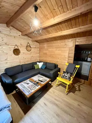 a living room with a couch and a table at Domek drewniany in Podzamcze