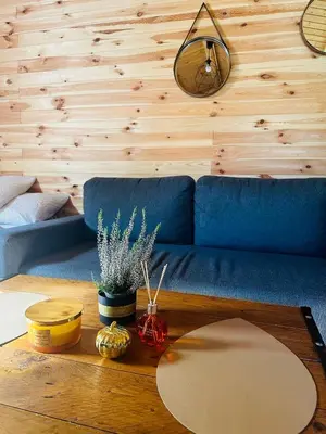 a living room with a blue couch and a table at Domek drewniany in Podzamcze