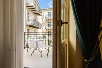 an open door to a balcony with a table and chairs at Vintage Sebastiana Apartment in Kraków