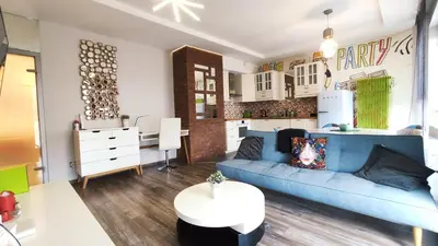 a living room with a blue couch and a kitchen at Wrocławska 80 by Homeprime in Kraków