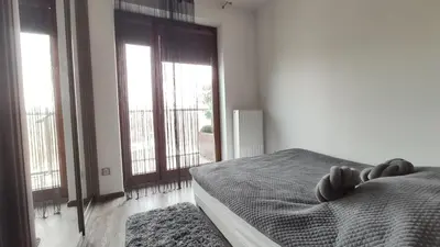 a bedroom with a bed and large windows at Wrocławska 80 by Homeprime in Kraków