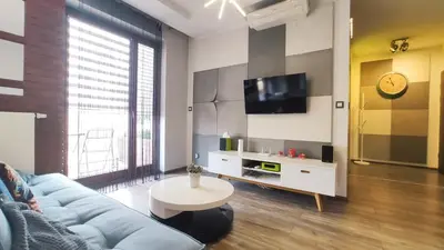 a living room with a blue couch and a tv at Wrocławska 80 by Homeprime in Kraków