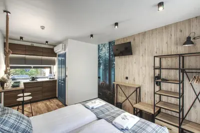 a bedroom with a bed and a kitchen in a room at Skansen Forest in Liszki