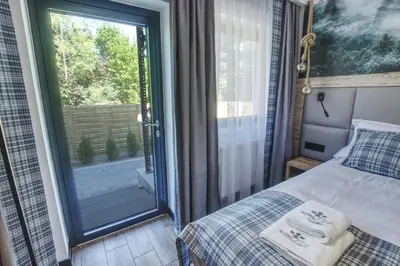 a bedroom with a bed and a sliding glass door at Skansen Forest in Liszki