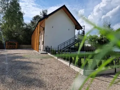 a large white building with a fence next to it at Skansen Forest in Liszki
