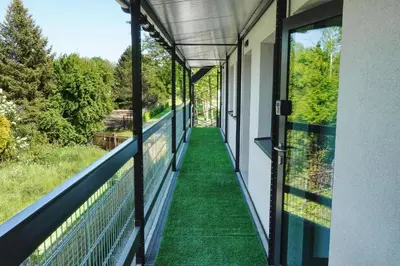 a balcony with green flooring and large windows at Skansen Forest in Liszki