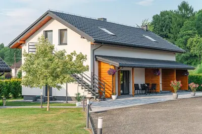 a white house with a black roof at Bianco Apartamenty Laskowa - Zator in Zator
