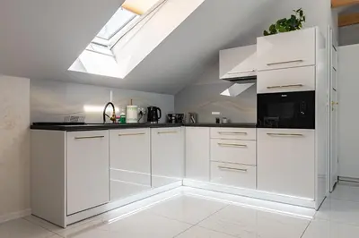 a kitchen with white cabinets and a skylight at Bianco Apartamenty Laskowa - Zator in Zator