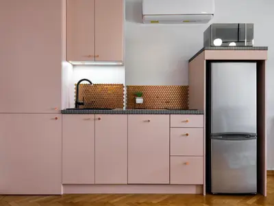 a kitchen with white cabinets and a refrigerator at CracWoW City Center Apartment in Kraków