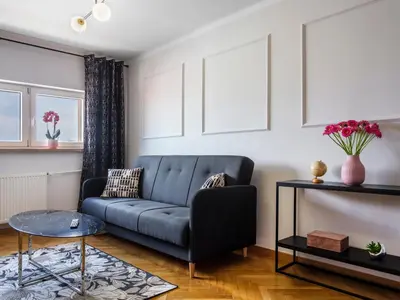 a living room with a blue couch and a table at CracWoW City Center Apartment in Kraków