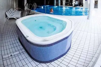 a large bath tub sitting next to a swimming pool at Premium Apartment for Old Town & Jewish Quarter plus Pool in Kraków