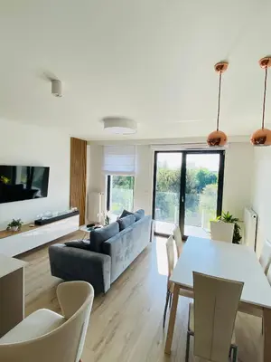 a living room with a table and a couch at Luxury White Apartment in Park Lotników in Kraków