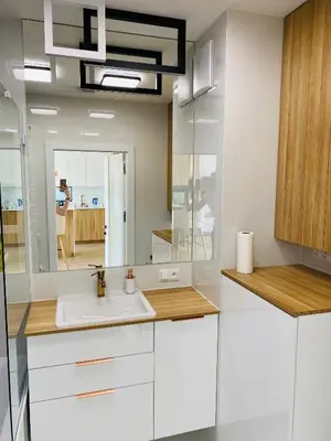 a white bathroom with a sink and a mirror at Luxury White Apartment in Park Lotników in Kraków