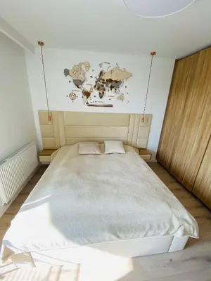 a bedroom with a large bed with a map on the wall at Luxury White Apartment in Park Lotników in Kraków