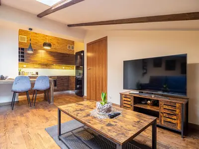 a living room with a table and a large television at Apartament Bocheńska in Kraków
