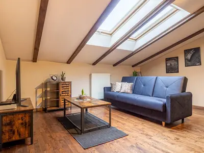 a living room with a blue couch and a tv at Apartament Bocheńska in Kraków