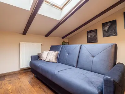 a blue couch in a room with a skylight at Apartament Bocheńska in Kraków