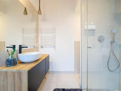 a bathroom with a sink and a shower at Apartament Bocheńska in Kraków