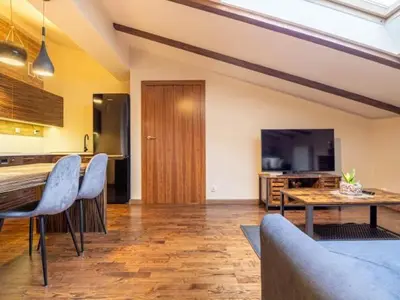 a living room with a kitchen and a table and chairs at Apartament Bocheńska in Kraków