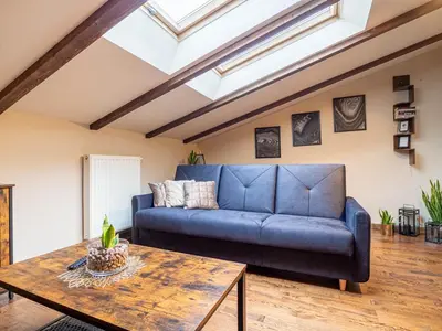 a living room with a blue couch and a table at Apartament Bocheńska in Kraków