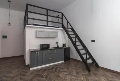 a kitchen with a bunk bed and a staircase in a room at Aparts Jablonowskich in Kraków