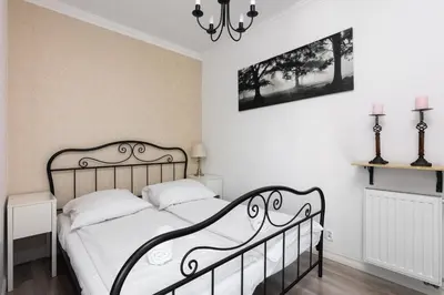 a white bedroom with a black and white bed at Pawia Apartments Modern 2 in Kraków