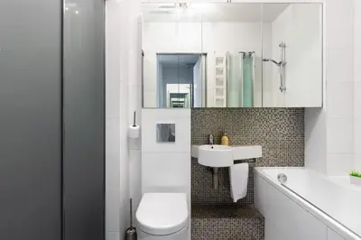 a white bathroom with a toilet and a sink at Pawia Apartments Modern 2 in Kraków