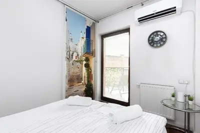 a white room with two beds and a window at Pawia Apartments Modern 2 in Kraków