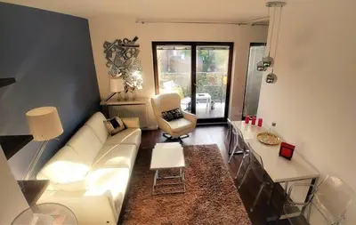 a living room with a white couch and a chair at Pawia Apartments Modern 2 in Kraków
