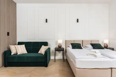 a bedroom with two beds and a green couch at Atrium - Old Town Luxury Apartments - by Upstairs in Kraków