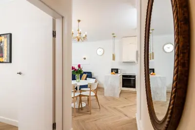 a living room with a dining room table and a mirror at Atrium - Old Town Luxury Apartments - by Upstairs in Kraków