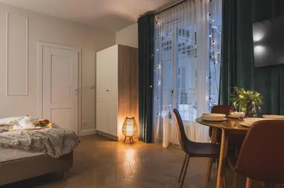a bedroom with a table and a dining room with a window at Atrium - Old Town Luxury Apartments - by Upstairs in Kraków