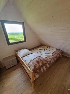 a small bed in a room with a window at Domki Harnaś Energylandia in Przeciszów