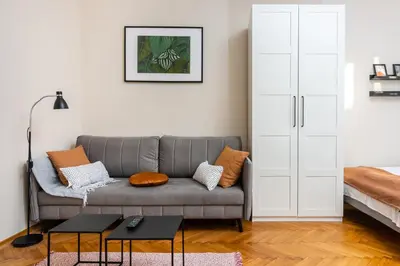 a living room with a gray couch with pillows at Spacious Apartment Around The Food Market - 5' to the Market Square - by Upstairs in Kraków