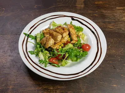 a plate of food with a salad on a table at Suite Loft in Zabierzów