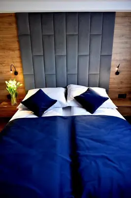 a bed with blue and white sheets and pillows at Apartament Anna in Bachowice