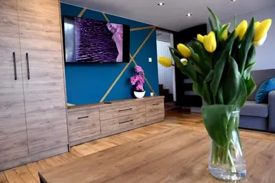 a living room with a vase of yellow flowers at Apartament Anna in Bachowice