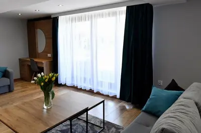 a living room with a couch and a table with flowers at Apartament Anna in Bachowice